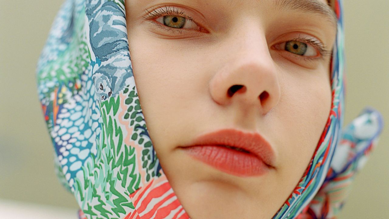 Close up portrait of wearing colorful scarf covering her hair and a tinted spf lip balm