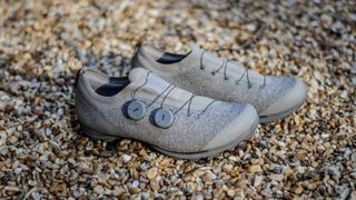 A pair of Rapha Pro Team Gravel shoes on some gravel 