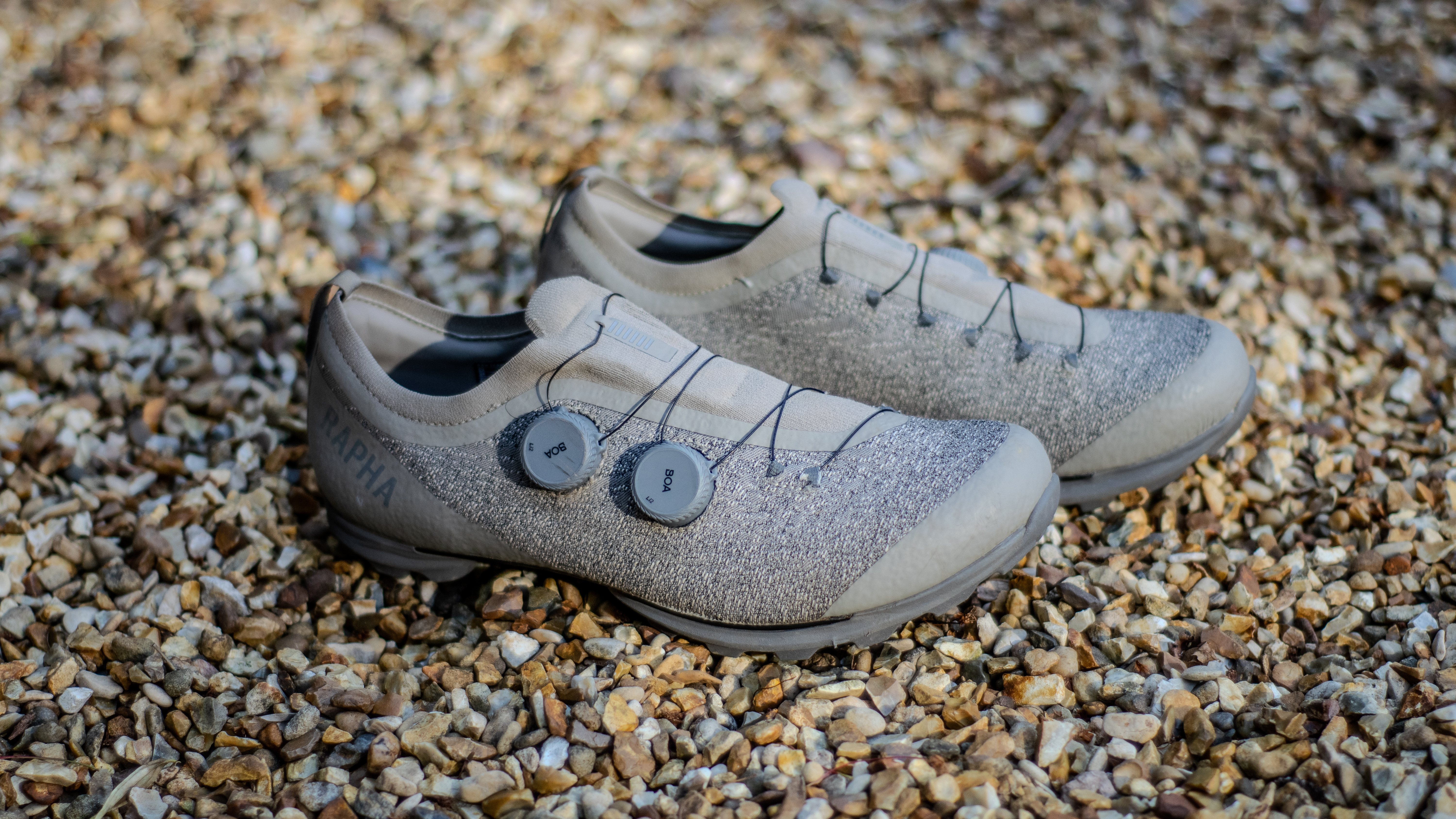 A pair of Rapha Pro Team Gravel shoes on some gravel 