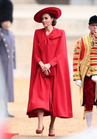 Kate Middleton in a red bow cape coat.