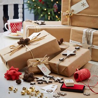 Several presents wrapped in brown wrapping paper with embellishments as decorations