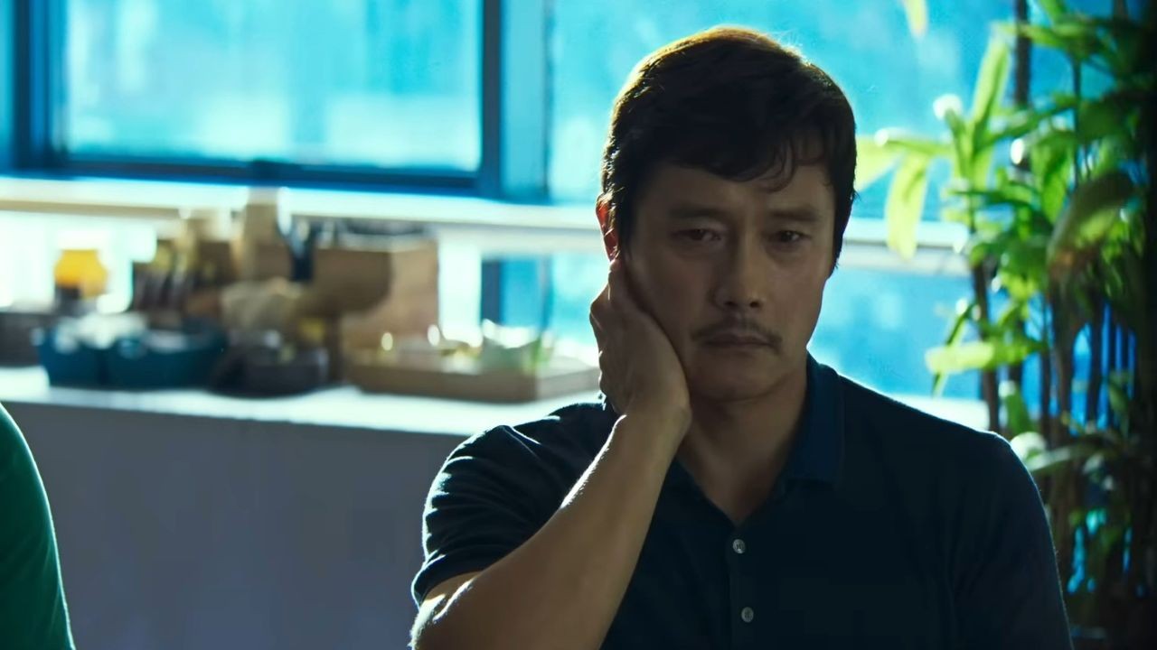 Lee Byung-hun hand on over mouth in No Other Choice.