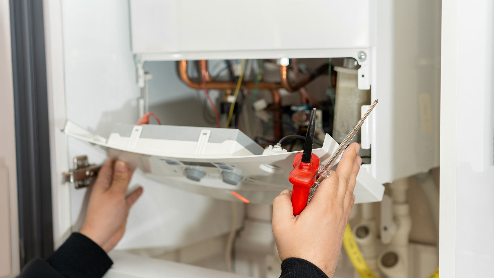 pair of hands installing a boiler