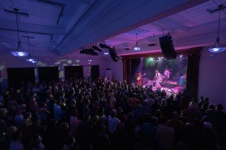 Blue, red, and purple lights shine on a live band as concertgoers stand and enjoy what WSDG helped bring to Hudson Valley’s newest live performance hub.