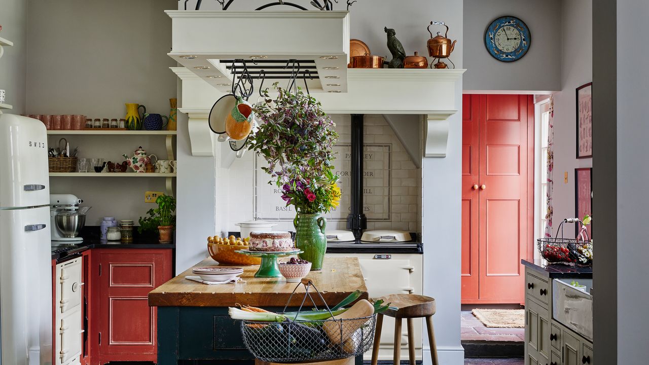 country kitchen with wooden topped island, cream range cooker and copper pots and pans