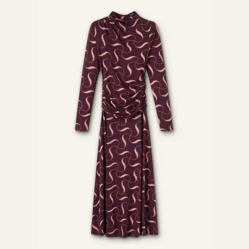 A cutout of a jersey maxi dress with burgundy and pink swirls on it set against a pale background