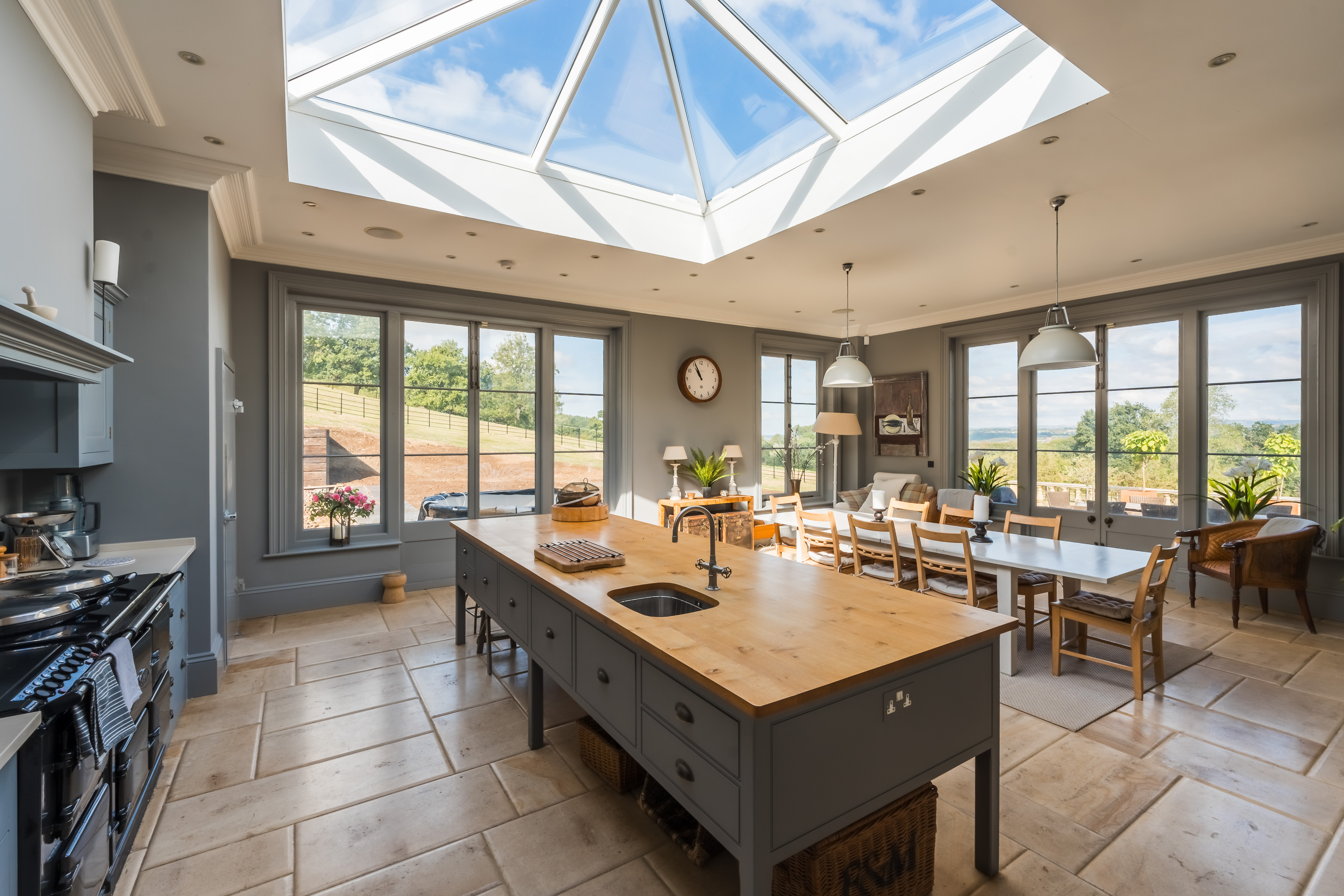 Photograph of an expansive and upmarket domestic kitchen with wrap-around windows looking onto a countryside setting. Captured by photographer and educator Nick Church, who will be speaking at The Photography &amp;amp; Video Show 2026