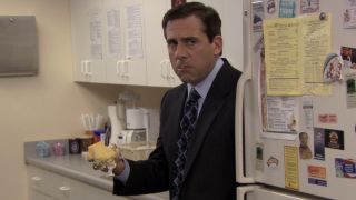 Michael holding a handful of cake in The Office