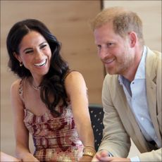 Meghan Markle laughs while wearing a pretty pink dress while looking at Prince Harry during their visit to Bogota, Colombia on August 15, 2024 