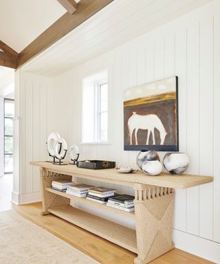 light and bright entryway with a large rattan table and a horse painting