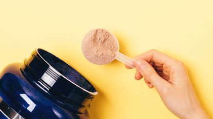 Person measuring a serving of protein powder