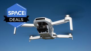 A white quadcopter with a black camera lens on the front is hovering in the air in front of a blue sky with the space.com logo in the top left corner.