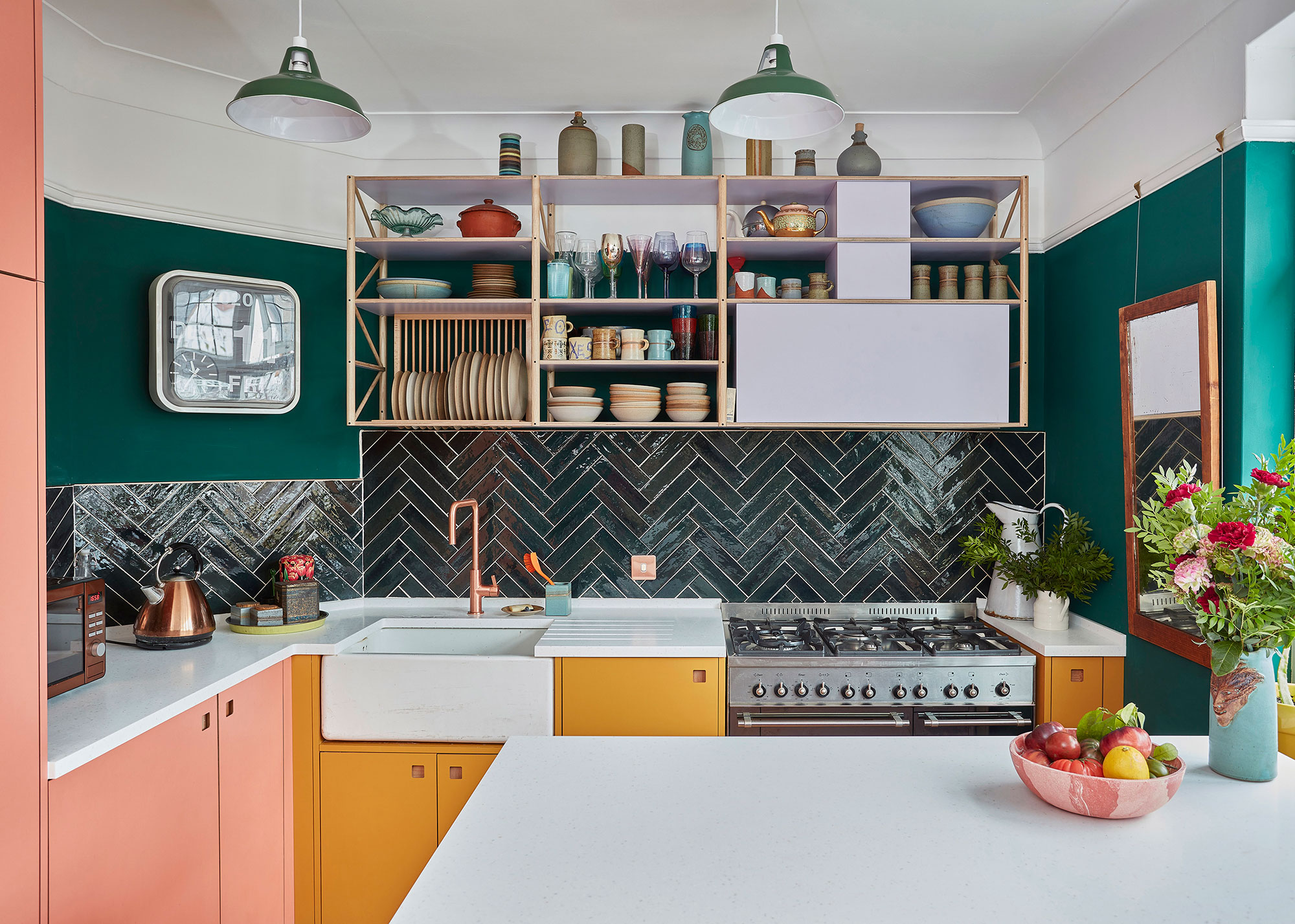 small pink and yellow kitchen with green walls and black herringbone wall tiles