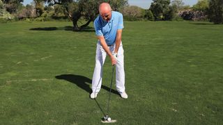 The hands are ahead of the ball when you set-up to play from a divot