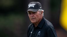 Gary Player wearing a black PXG cap and black polo shirt