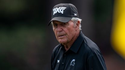 Gary Player wearing a black PXG cap and black polo shirt