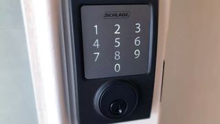Schlage Sense smart door lock in matte black installed on a door.