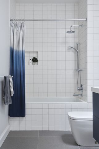 A bathroom with a blue shower curtain