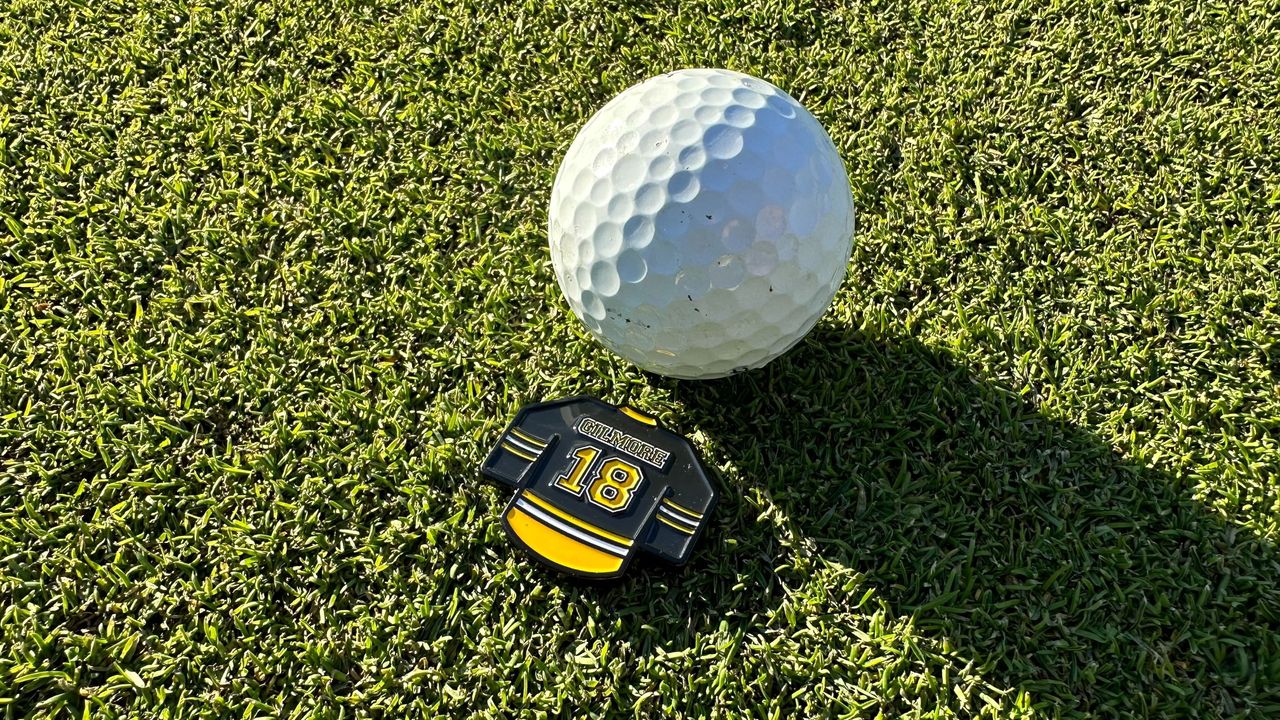 A Happy Gilmore ball marker behind a golf ball on the green