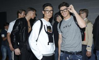 Two males posing, wearing black glasses