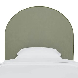A curved green headboard with white bedding