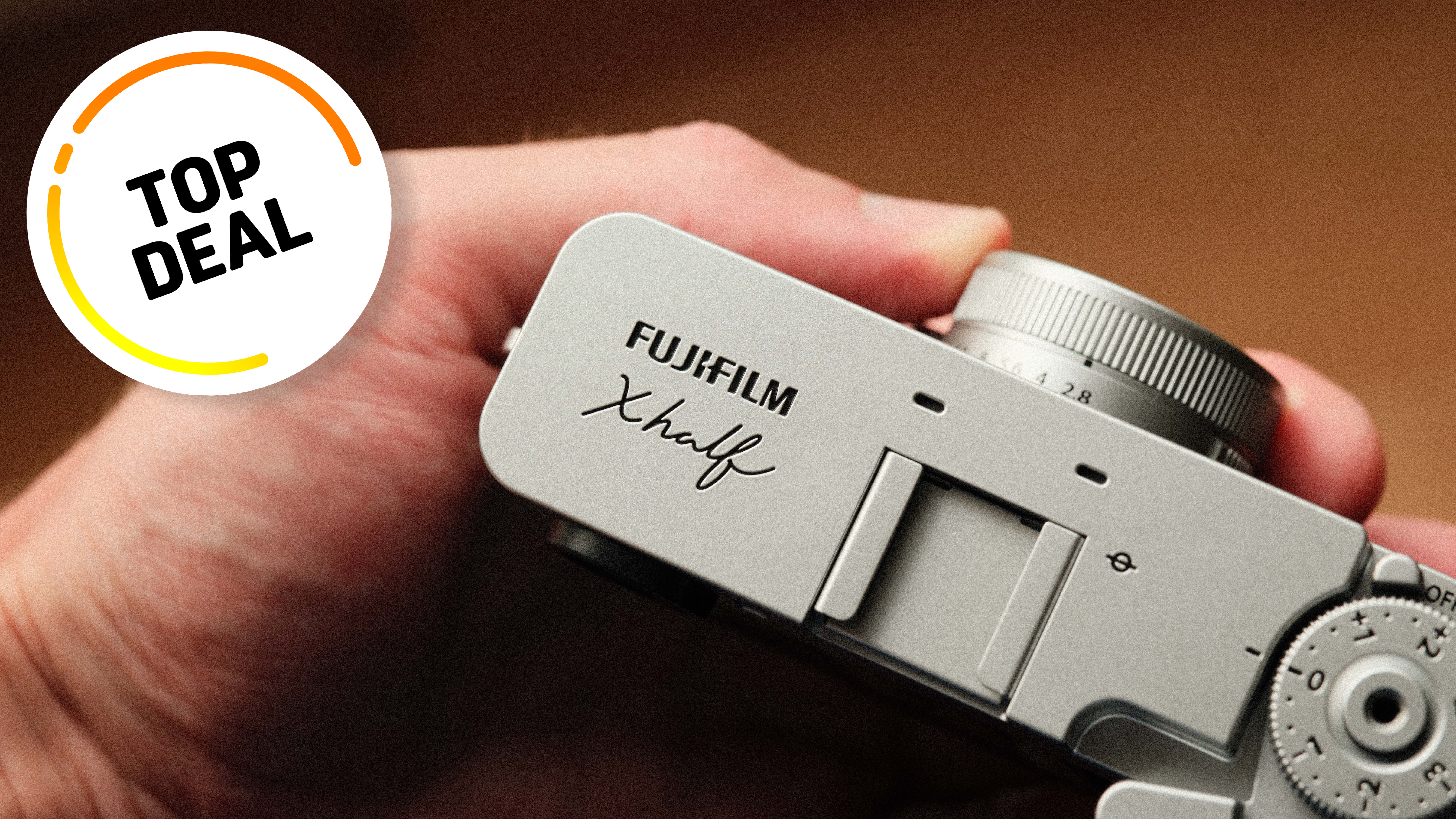 A hand holding the Fujifilm X Half camera with a Top Deal badge overlay