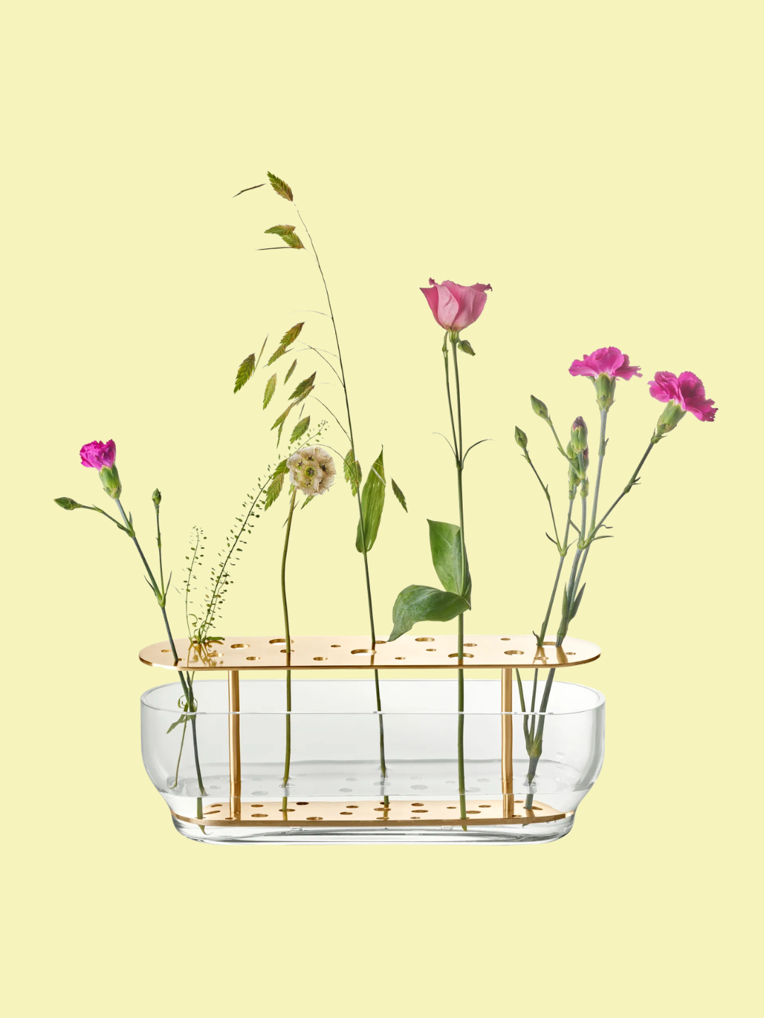 A long transparent and gold ikebana vase with flowers