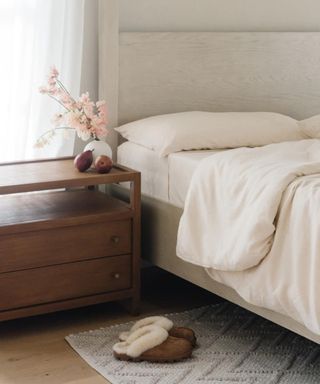 Cozy Earth Bamboo Bed Sheets in white on a bed beside a wooden nightstand.