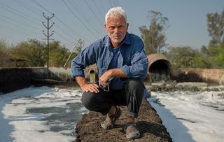 Jeremy Wade in front of pollution pouring into the River Ganges