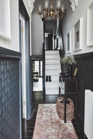 Monochrome hallway with white wooden staircase and a high ceiling