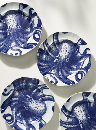 four white plates with blue octopus painted on them