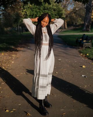 Influencer styles a white maxi dress with black knee boots