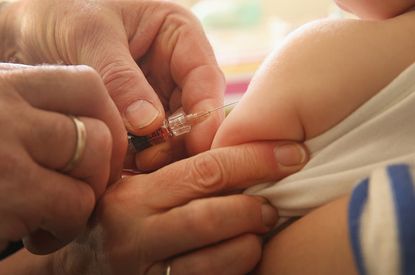 A baby receives an immunization shot.