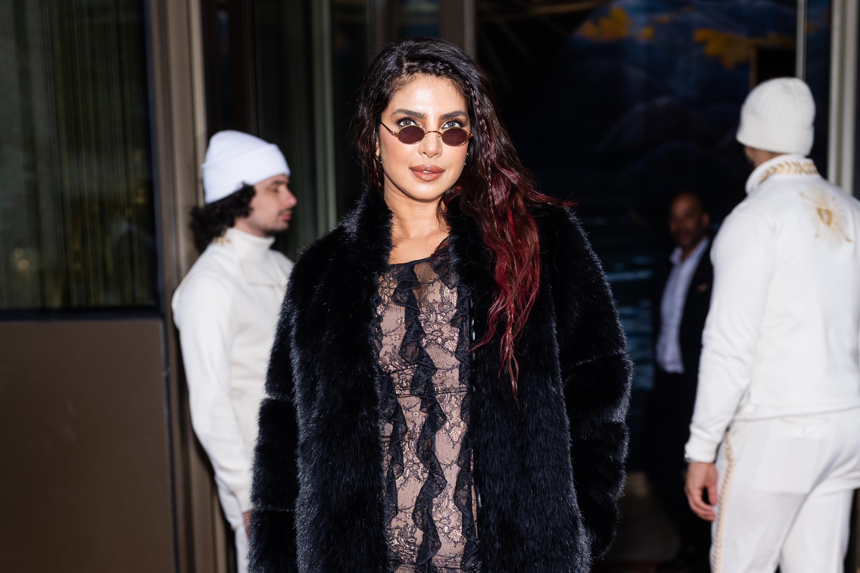 a woman with dark hair dip dyed red photographed in a lacy black dress and a black fur coat