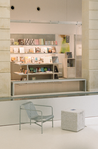 A brutalist building houses a spirited bookshop filled with coffee table volumes in striking hues.