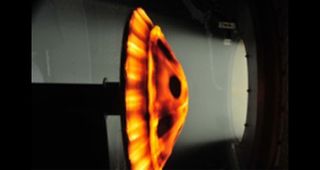 A NASA inflatable heat shield prototype is subjected to the searing hot temperatures of a simulated re-entry in this image.