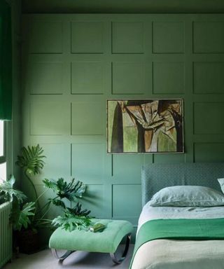 Green monochrome bedroom with artwork and plant