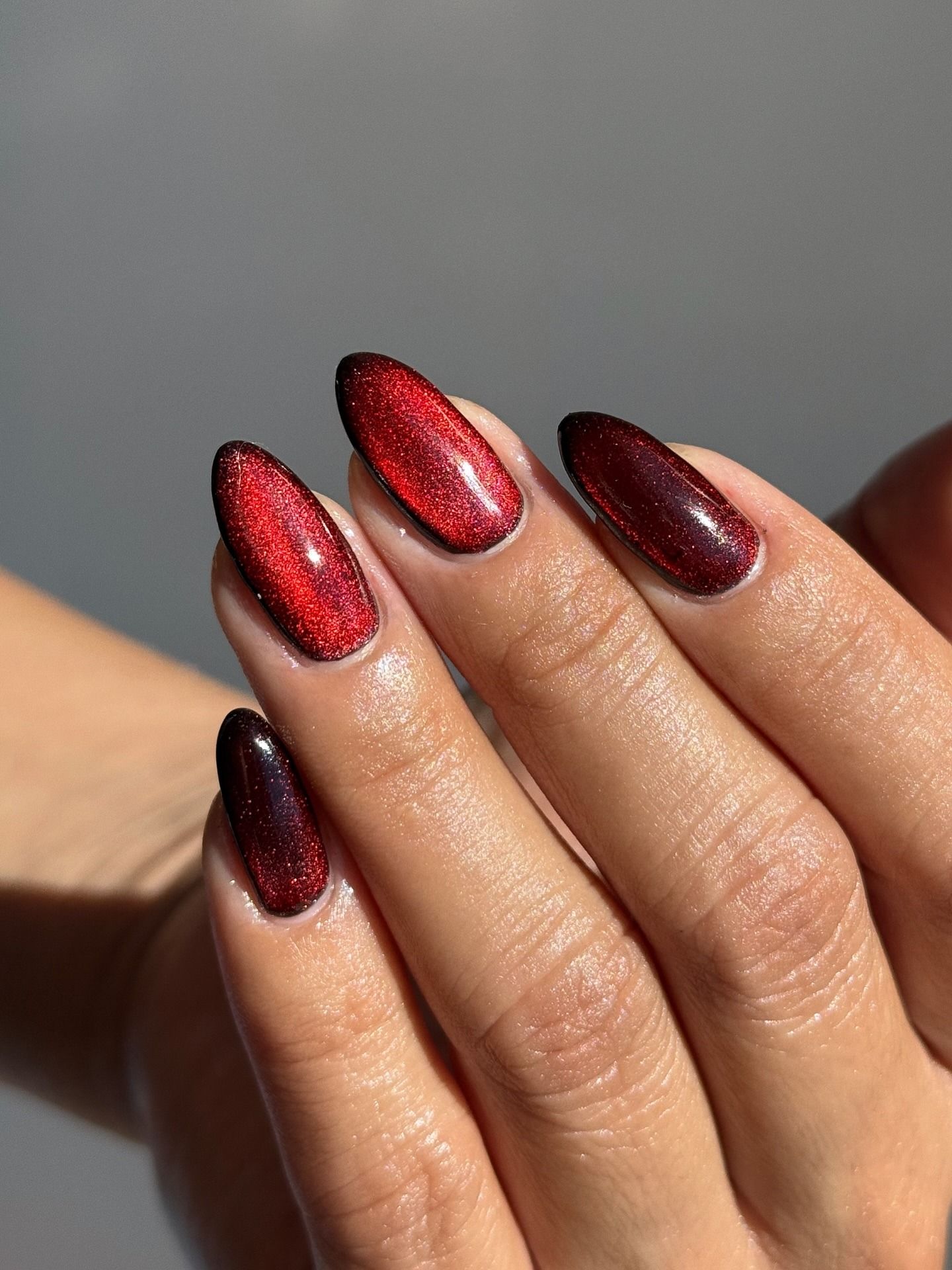 A close-up picture of red cat-eye nails