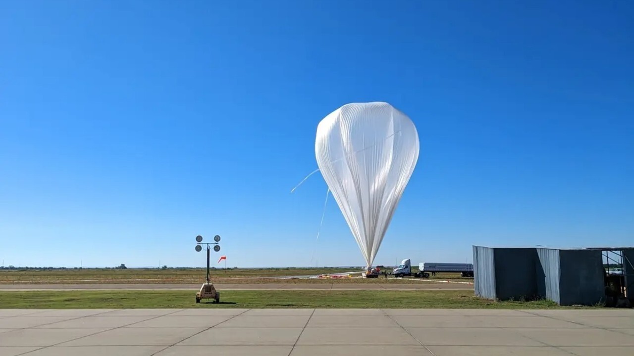 A white balloon is seen landing on a grassy lawn