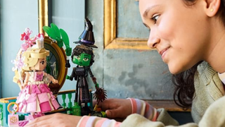 A young person admiring their Lego Wicked Glinda and Elphaba figures