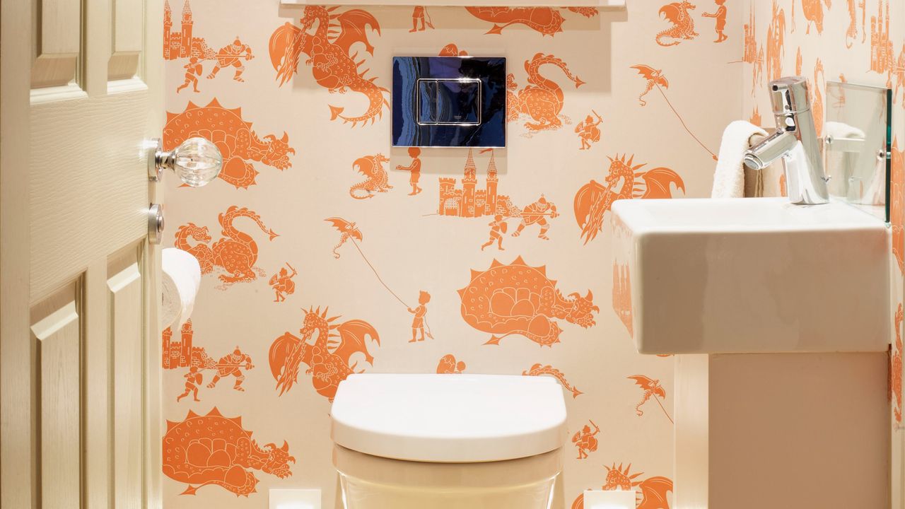 A cloakroom covered in a cream and orange illustrated wallpaper