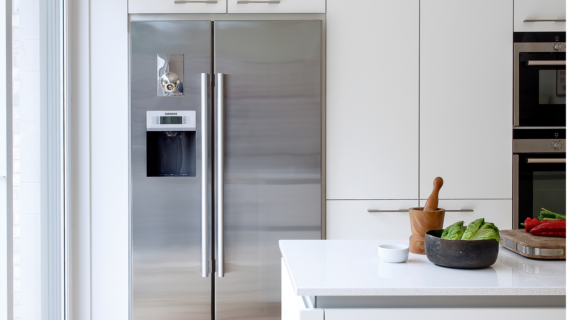 White kitchen with chrome double fridge freezer