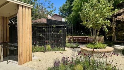 a garden with an outdoor kitchen, and a round central planter, 