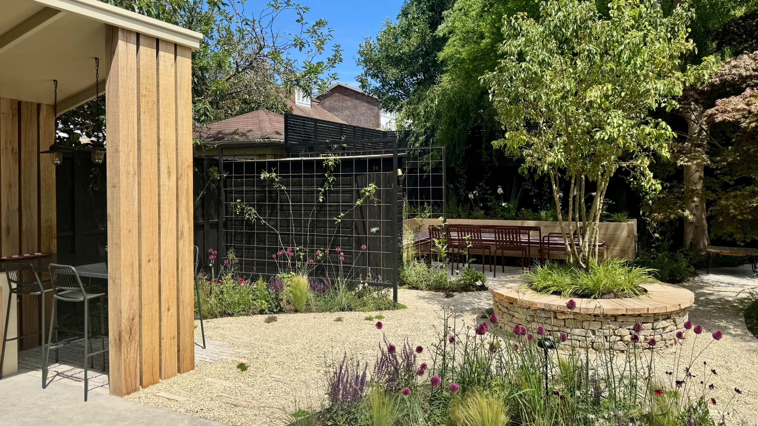 a garden with an outdoor kitchen, and a round central planter, 