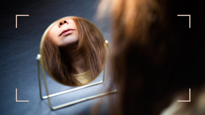 woman looking at mouth in mirror 