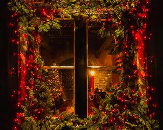 red star christmas lights around window with foliage