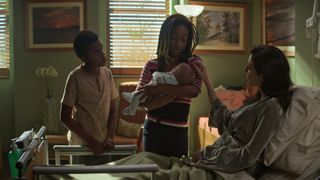 Rose holds Lyta's baby as Lyta looks on in The Sandman season 1