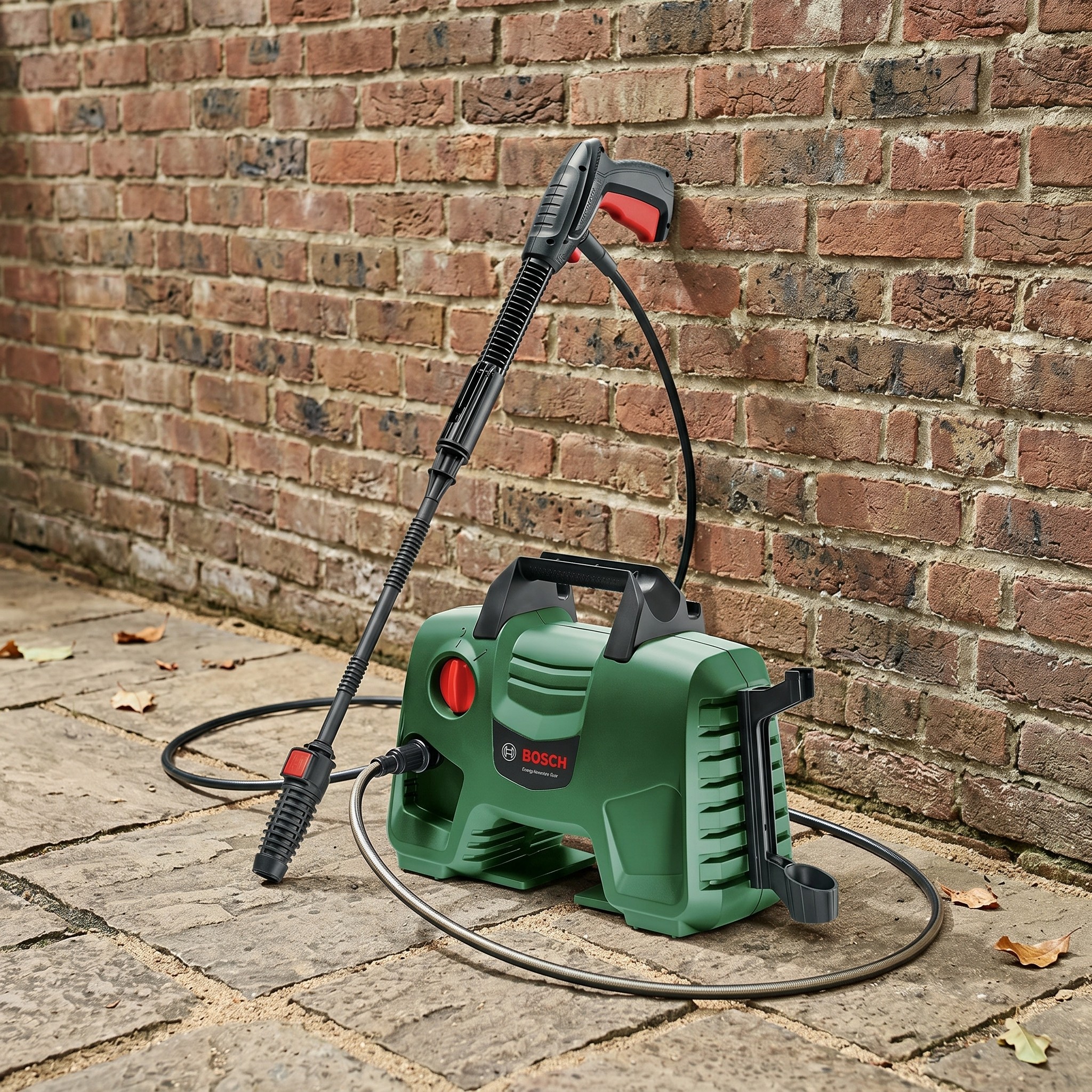 Pressure washer against a brick wall on a patio floor