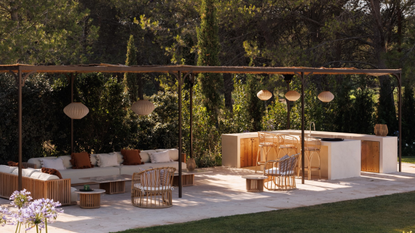 An outdoor kitchen and seating area covered with wooden beams