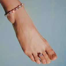 a woman wearing an AFLALO and Leandra Medine Cohen diamond toe ring and diamond anklet